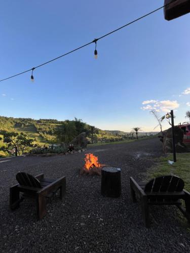 a campfire with two chairs and a fire pit at Refúgio Da Lua - Buss motorhome in Ametista do Sul