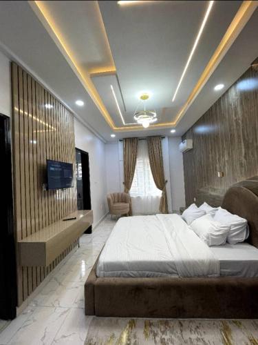 a bedroom with a large bed and a tv in it at Deluxe Haven Apartment in Lekki