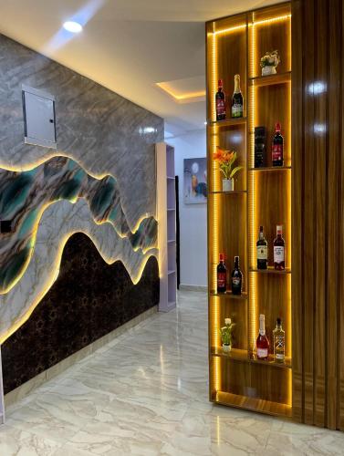 a lobby with a wall with bottles of alcohol at Deluxe Haven Apartment in Lekki