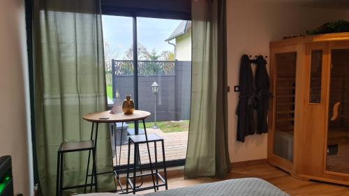 une pièce avec une table, des chaises et une fenêtre dans l'établissement La Cabane Secrète, à Bouquelon