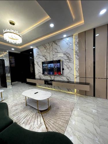 a lobby with a table and a tv on a wall at Deluxe Haven Apartment in Lekki