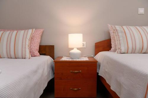 a bedroom with two beds and a lamp on a dresser at Anastasia's House in Plátanos