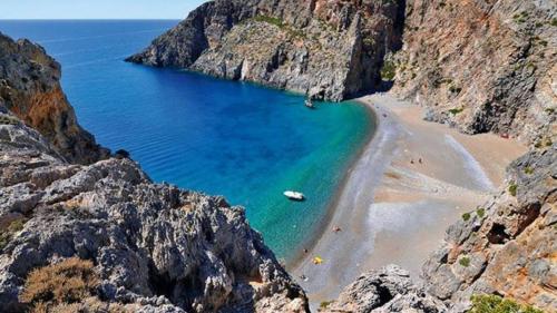 a view of a beach between two rocky cliffs at Anastasia's House in Plátanos