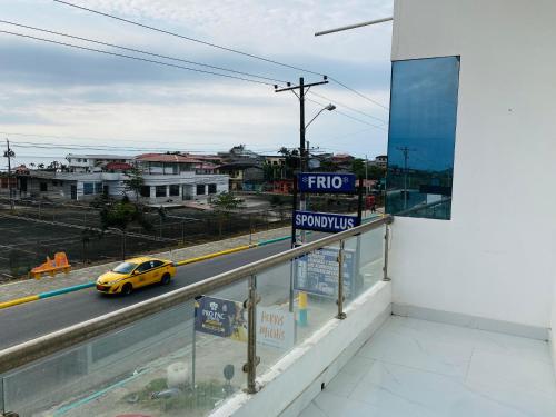 a view of a street from a balcony with a taxi at Apartamento Ciudad del Surf Montañita in Montañita