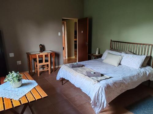 a bedroom with a large bed and a table at The View Holiday Home in Graskop