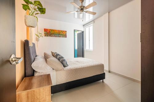 Un dormitorio con una cama y un ventilador de techo. en Casa Oasis, en Villavicencio