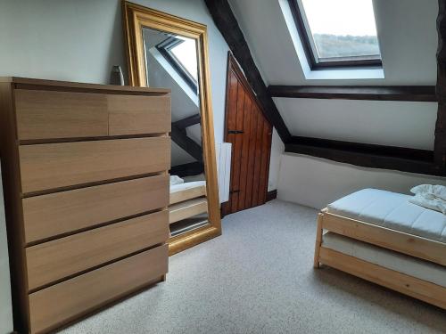 a bedroom with a dresser and a mirror in it at Châteauneuf-du-Faou, Finistre, Brittany in Châteauneuf-du-Faou