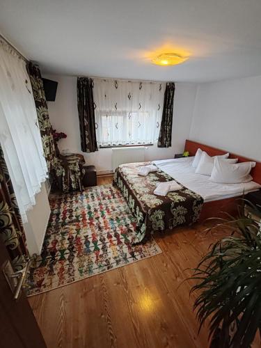 a bedroom with a bed and a rug on the floor at Casa Alex in Topliţa