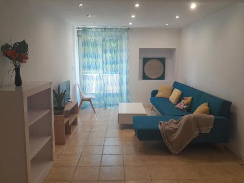 un salon avec un canapé bleu et une table dans l'établissement séjour au pays des Béarn, à Baigts-de-Béarn