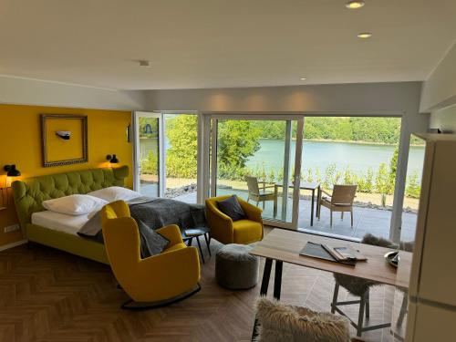 a bedroom with a bed and a table and chairs at Ommi Kese See-Suite Sauna Biggesee in Olpe