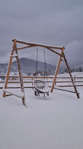 a swing in the snow on a snow covered fence at Guest House Zabljak in Žabljak