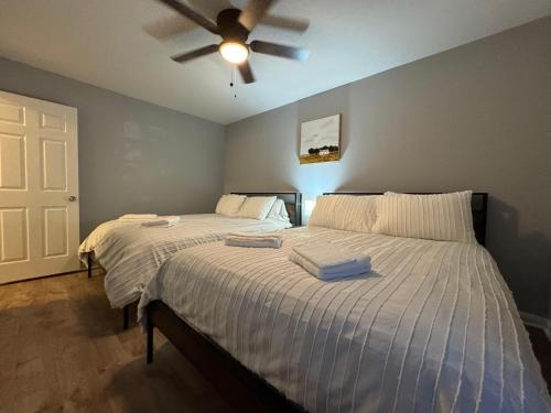 Un dormitorio con dos camas y un ventilador de techo. en 3 Bedroom Townhouse-Max 8 guests, en Charlotte