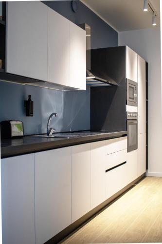 a kitchen with white cabinets and a sink at Gonin 58 in Milan