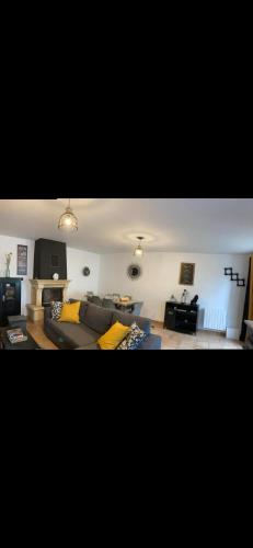 un salon avec un canapé et une table dans l'établissement Chez Nadine, à Saint-Georges-de-Reintembault