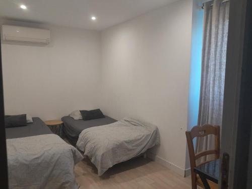 Habitación con 2 camas individuales y silla en séjour au pays des Béarn, en Baigts-de-Béarn