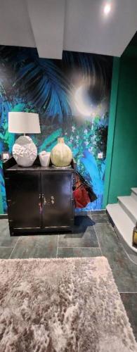 une chambre avec une table avec une lampe et un tableau dans l'établissement la bastide du soleil, à Villeneuve-lès-Béziers