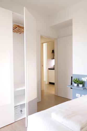 a bedroom with white walls and a large mirror at Gonin 58 in Milan
