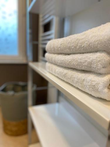 a pile of towels sitting on a shelf at Château, poteries, vins et randonnées in Saint-Amand-en-Puisaye