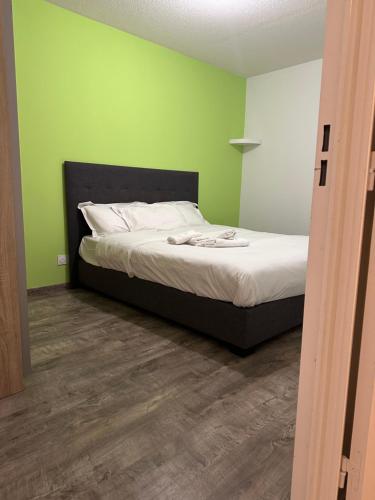 Ce lit se trouve dans un dortoir aux murs verts. dans l'établissement Le reflet d'Ambre, à Gex