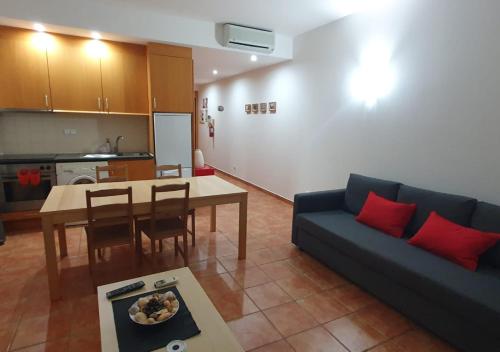 a living room with a couch and a table and a kitchen at Apartment Belleview in Lagos