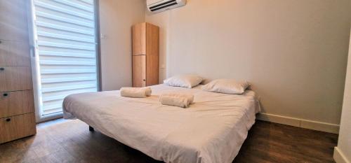 une chambre avec un lit avec deux oreillers dessus dans l'établissement UNIQUE appartement direct PLAGE COMMERCES PARKING PRIVEE CLIM NEUF WIFI, à Banyuls-sur-Mer