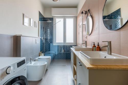 a bathroom with a sink and a washing machine at Oasis Apartment in Bologna