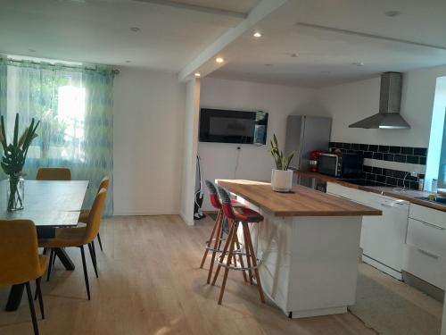 Una cocina con encimera y mesa con sillas. en séjour au pays des Béarn, en Baigts-de-Béarn