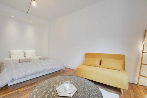 une chambre avec un lit, un canapé et une table dans l'établissement Appartement place Stanislas 1er, à Nancy