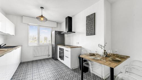a kitchen with a table and a refrigerator at Coloc Dormant - Hyper-centre, proche transports pour Genève. in Annemasse