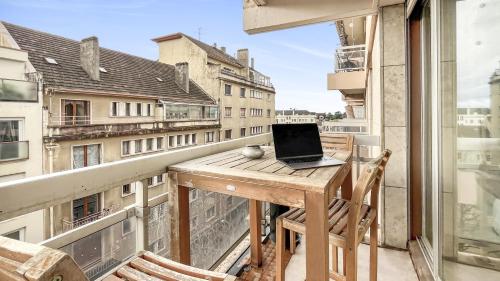 a laptop computer sitting on a table on a balcony at Coloc Dormant - Hyper-centre, proche transports pour Genève. in Annemasse
