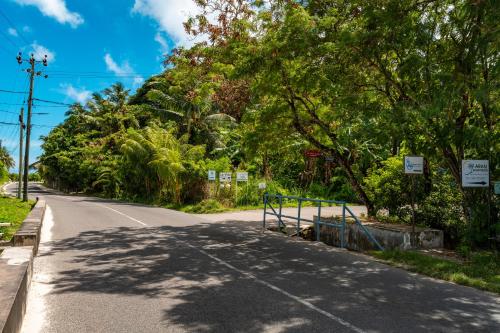 an empty road with trees on the side of the road at Aran Apartments in Au Cap