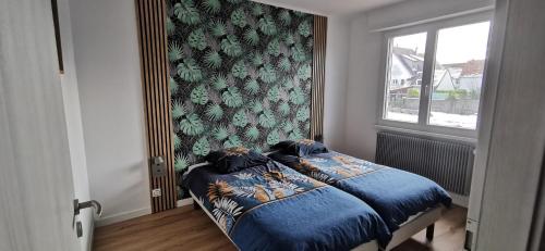 une chambre avec un lit avec des draps bleus et une fenêtre dans l'établissement Maison avec jardin proche Europa-Park Rulantica Strasbourg Colmar, à Rhinau