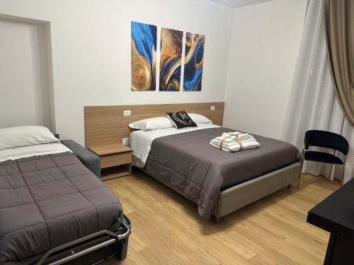 a bedroom with two beds and a painting on the wall at Royal Residence in Santa Maria Capua Vetere