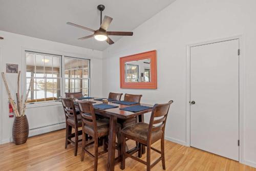a dining room with a table and chairs and a ceiling fan at Tranquil 3BR Retreat Game Room Deck Beach Pass in Center Harbor
