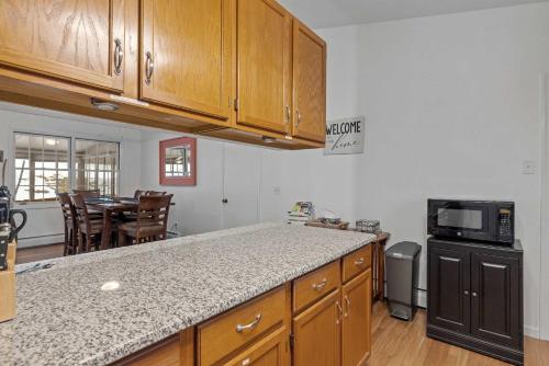 a kitchen with wooden cabinets and a counter top at Tranquil 3BR Retreat Game Room Deck Beach Pass in Center Harbor