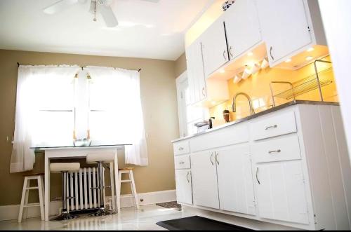a kitchen with white cabinets and a sink and a window at Sunshine Room by harbor downtown beach I-95&Train in Stamford