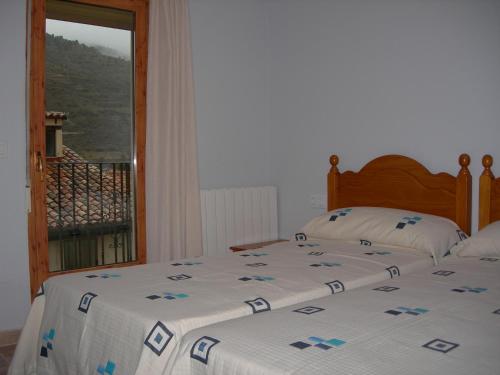 a bedroom with a bed and a window with a view at Apartamentos Turísticos Rosario in Camarena de la Sierra