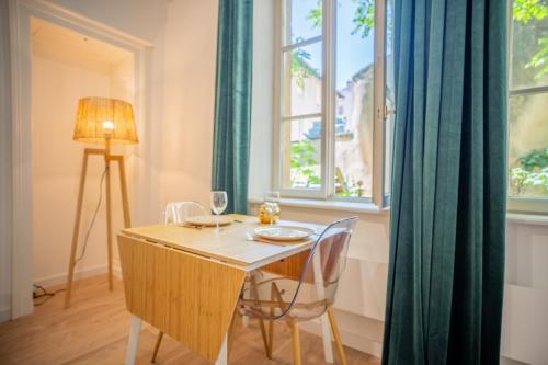 a dining room with a table and chairs and a window at Bel appartement coeur de ville in Metz