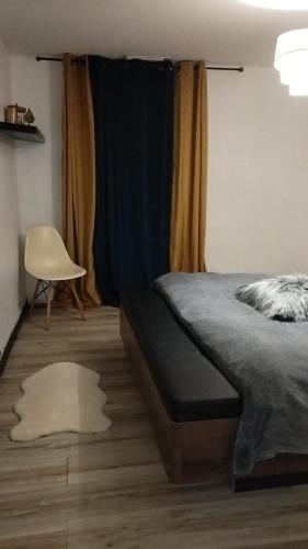 a bedroom with a bed and a chair and a window at Séjour au Pyrénées Atlantique in Baigts-de-Béarn