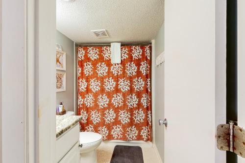 a bathroom with a toilet and a shower curtain at HB289 Feel the Burn in Holden Beach