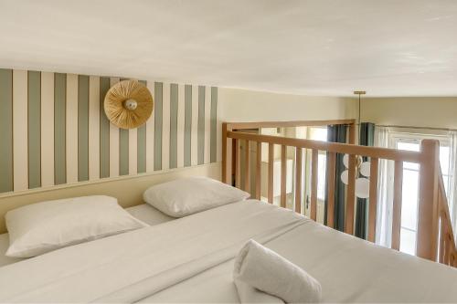 ein Schlafzimmer mit einem Bett und einer Uhr an der Wand in der Unterkunft Le Saint Julien in Versailles