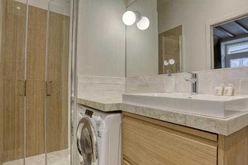 ein Badezimmer mit Waschbecken und Waschmaschine in der Unterkunft Le Saint Julien in Versailles