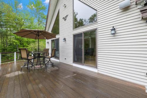 a patio with an umbrella and a table and chairs at Trails & Tranquility Great Nature Game Room in Freedom