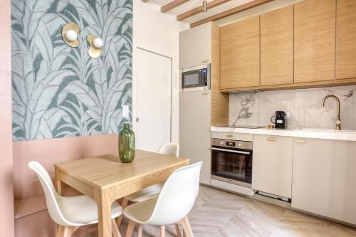 - une cuisine avec une table en bois et des chaises blanches dans l'établissement Le Saint Julien, à Versailles