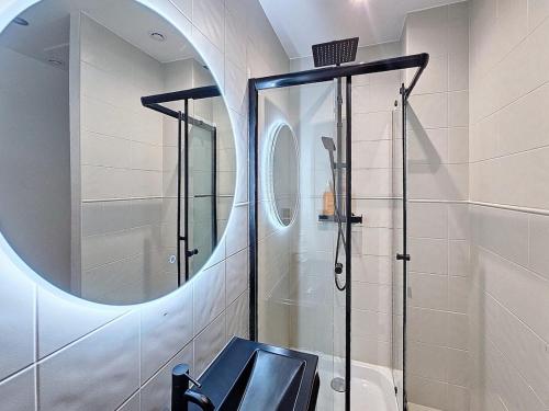 La salle de bains est pourvue d'une douche en verre et d'un miroir. dans l'établissement Le Carré Or Lyon 6 Boulevard des Belges , 2 Bedrooms, à Lyon