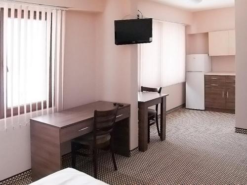 een hotelkamer met een bureau en een televisie bij Motel Maritsa in Dimitrovgrad