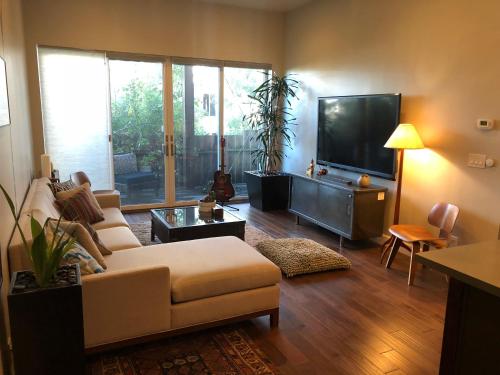 a living room with a couch and a flat screen tv at Beautiful Cottage, hot tub, in great neighborhood in San Francisco