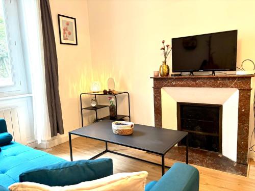 un salon avec un canapé bleu et une cheminée dans l'établissement LE LEGUE, à Saint-Brieuc