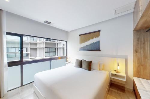 een slaapkamer met een groot wit bed en een raam bij Golden Wave Escape in Playa del Carmen