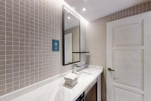 een badkamer met een wastafel en een spiegel bij Golden Wave Escape in Playa del Carmen